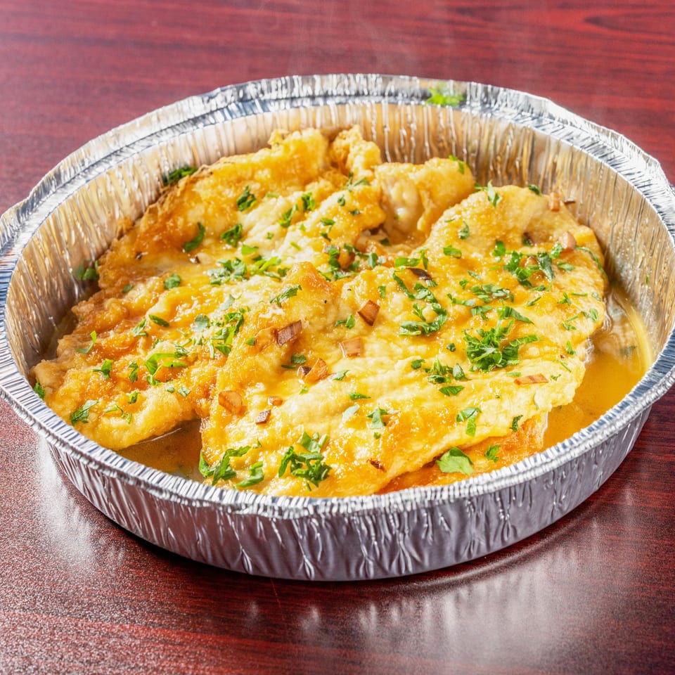 Chicken Francese in a catering tray.